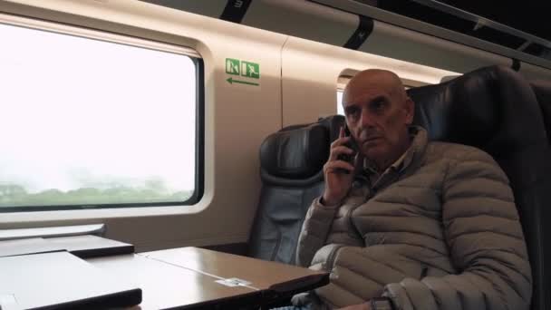 Vanha Liikemies Soittaa Työpuhelun Matkustaessaan Junassa — kuvapankkivideo