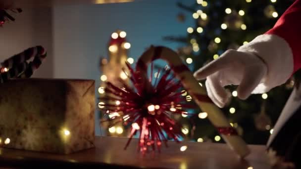 圣诞老人的手晚上把书从书架上拿到圣诞树旁 — 图库视频影像