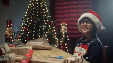 Çocuk masasında gülümseyip hediyeler hazırlıyor. .