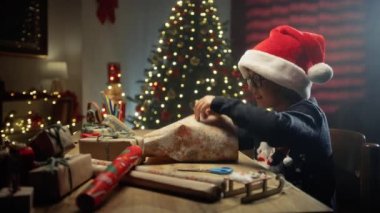 Noel hediyelerini paketleyen çocuk. . 