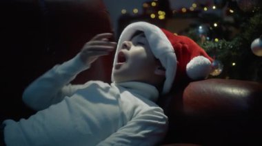 Noel şapkalı çocuk ağacın altında uyuyakalıyor.. 