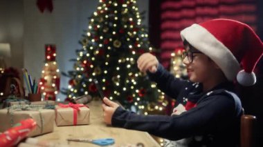 Genç bir çocuk video görüşmesi sırasında ailesini selamlıyor. . 