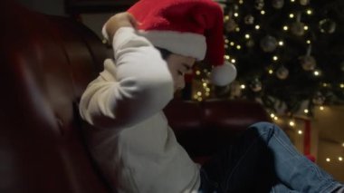 Çocuk Noel Baba şapkası takıyor ve gülümsüyor. . 