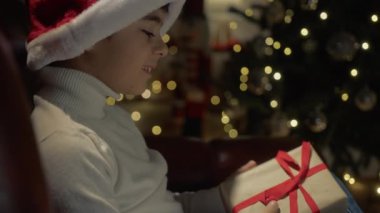 Genç çocuk Noel hediyesini merak ediyor. . 