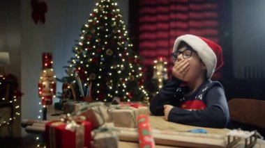 Çocuk Noel ağacının altında uyuyakalıyor ve ışıklar sönüyor. . 