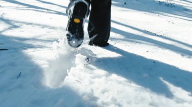 Çizmelerle karda yürüyen kişi yavaşça iz bırakır. . 