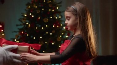 Genç kız Noel Baba 'dan hediye alıyor. .