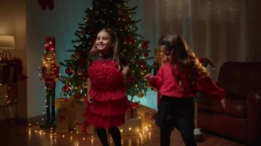 Genç kızlar Noel ağacının altında dans ediyor . 