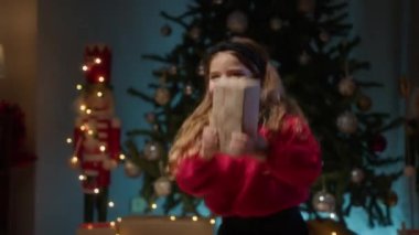 Mutlu kız atlıyor ve gülümsüyor Noel hediyesine . 