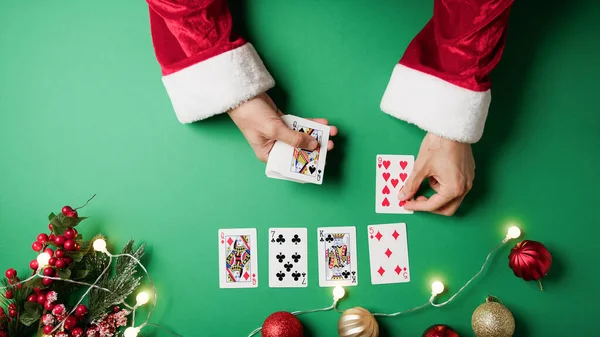 Santa Claus playing solitaire with cards .