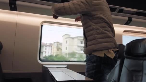 高级乘客在坐火车时站起来取包 — 图库视频影像