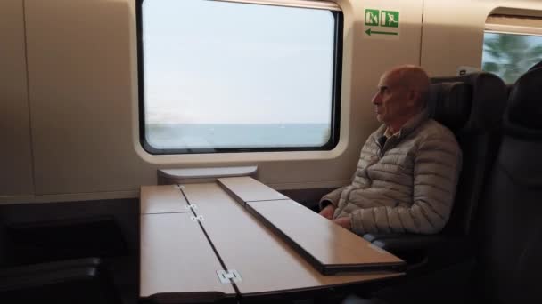 彼の列車に乗ってリラックスして海を見ながら楽しむ老人 — ストック動画