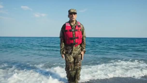 海の近くの海岸でジャンプジャックを訓練する軍人の男 — ストック動画