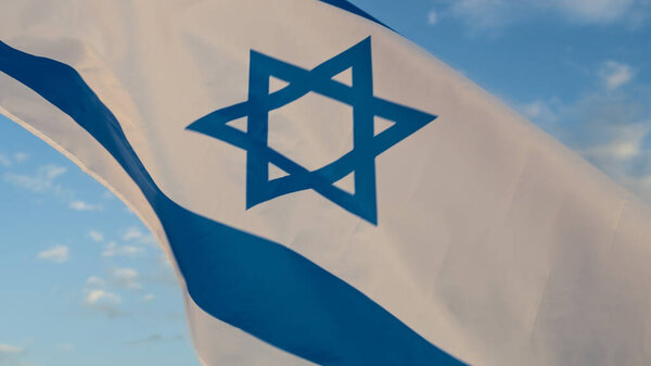 Государственный флаг Израиля, машущий на фоне неба .