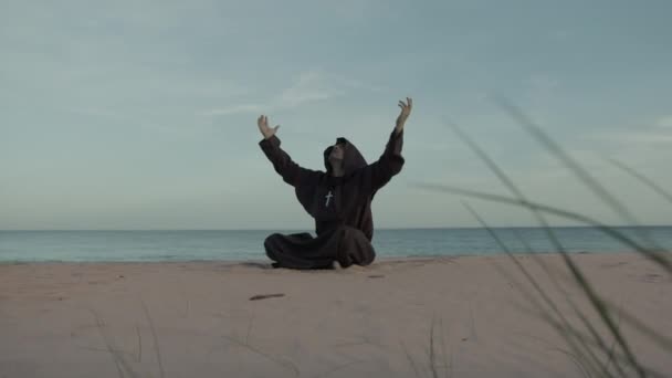 モンクは厳粛な祈りの中でビーチで最も偉大な座席から助けを求める — ストック動画
