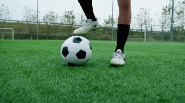 Futbol topuyla oynayan bir çocuğun ayakları..
