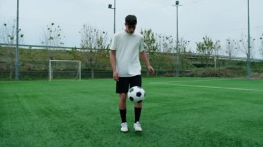 Serbest stil futbol sahasında top sürüyor.