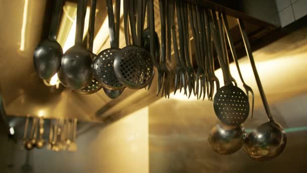 Ladles Και Skimmers Κρέμεται Στην Κουκούλα Ενός Εστιατορίου Κουζίνα — Αρχείο Βίντεο
