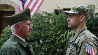Asker ve gazi Amerikan askeri bayrağında birbirlerine bakıyorlar..