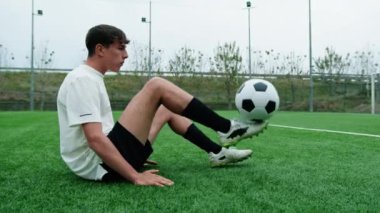 Genç Futbolcu Sahada Oturan Futbol Serbest Stil Oyunları Yapıyor.