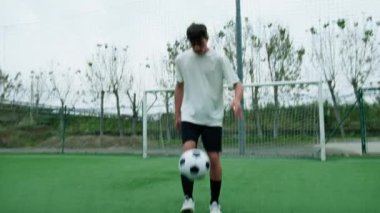Gençler gol çizgisine yaklaşan futbol topuyla top sürüyor.