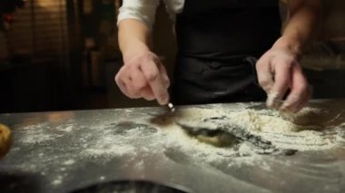 Şef, hamur işini un yumurtası ve mürekkep balığı ile karıştırıp lokantaya koyar..