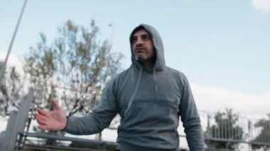 Beyaz adam parkta antrenman yapıyor..