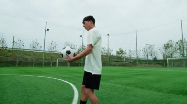 Sportif genç futbolcu sahada serbest futbol oynuyor..