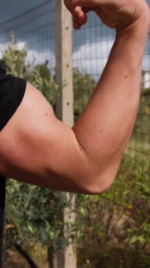 Oğlan, arka bahçede kaslarını kasıyor..