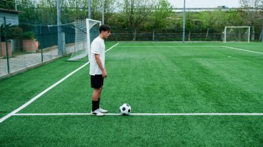 Genç, serbest stil futbol sahada top sürüyor..