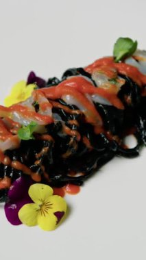 Karides ve vişneli domates soslu siyah mürekkepbalığı spagettisi.