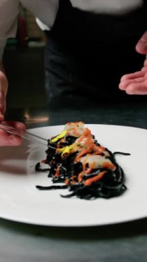 Karides ve vişneli domates soslu siyah mürekkepbalığı spagettisi..