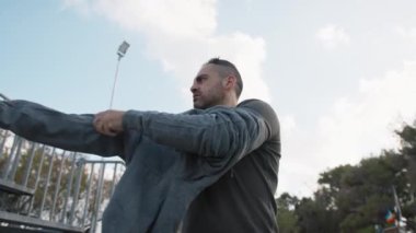 Beyaz adam parkta antrenman yapıyor..