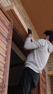 Adam evdeki pencerede barfiks çekiyor..