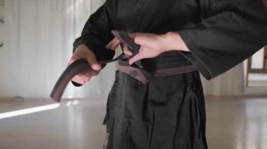 İki sporcu kapalı odada karate egzersizi yapıyor..