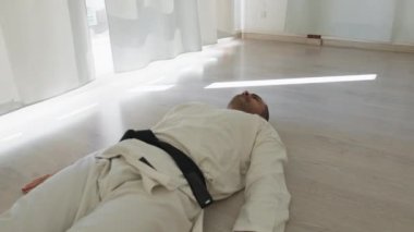 İki sporcu kapalı odada karate egzersizi yapıyor..