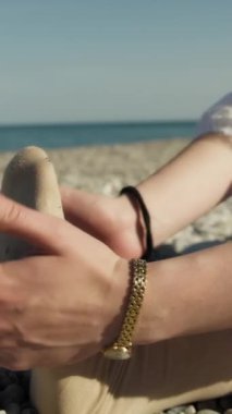 Yazın plajda beyazlar içinde dans eden genç bir kadın.