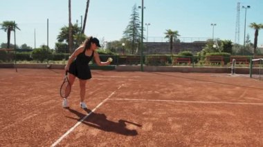 Bayan eğitmen, gündüz vakti Clay Court 'ta tenis öğretiyor..