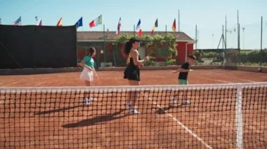 Bayan eğitmen, gündüz vakti Clay Court 'ta tenis öğretiyor..