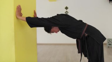 İki kıdemli karate uzmanı Kimono ile jimnastik yapıyor..