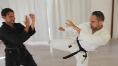 İki kıdemli karate uzmanı Kimono ile jimnastik yapıyor..