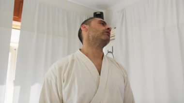 İki kıdemli karate uzmanı Kimono ile jimnastik yapıyor..