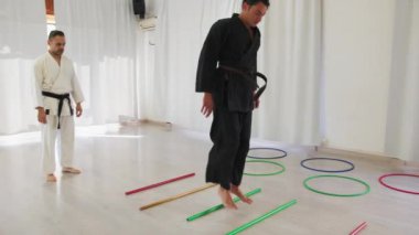 İki kıdemli karate uzmanı Kimono ile jimnastik yapıyor..