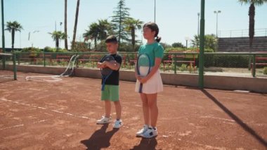 Bayan eğitmen, gündüz vakti Clay Court 'ta tenis öğretiyor..