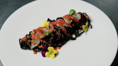 Karides ve vişneli domates soslu siyah mürekkepbalığı spagettisi.