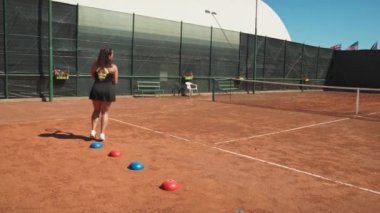 Bayan eğitmen, gündüz vakti Clay Court 'ta tenis öğretiyor..