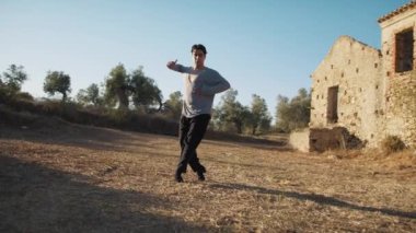 Genç çocuk kalenin yanındaki tepede Latin americano balesi yapıyor..