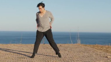 Genç çocuk kalenin yanındaki tepede Latin americano balesi yapıyor..