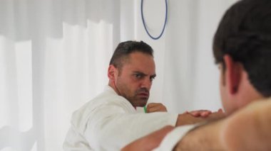 İki kıdemli karate uzmanı Kimono ile jimnastik yapıyor..