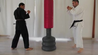 İki kıdemli karate uzmanı Kimono ile jimnastik yapıyor..